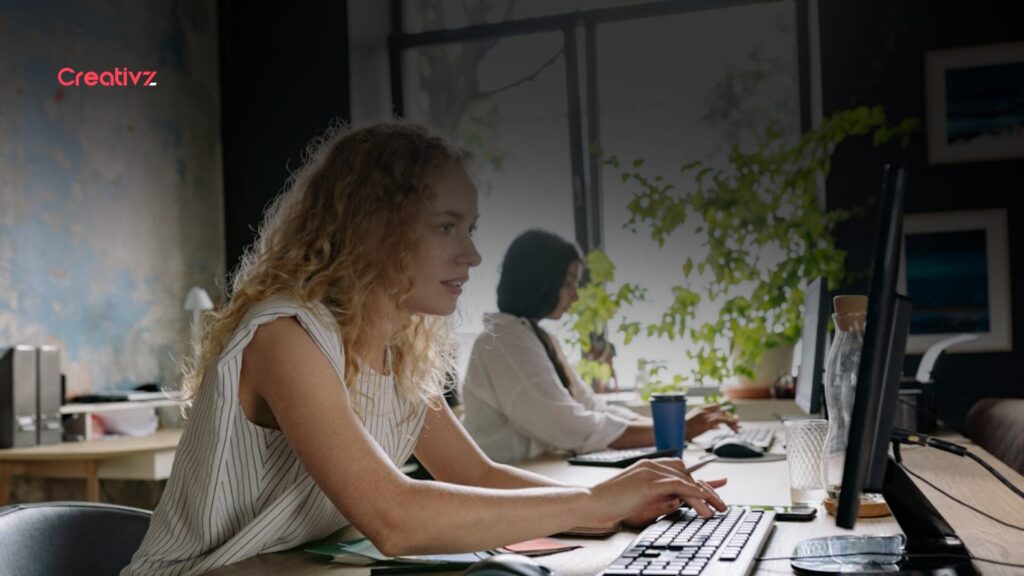 B2B marketing professional researching zero-click search behavior and AI-driven buyer journeys on a desktop computer in a modern office.