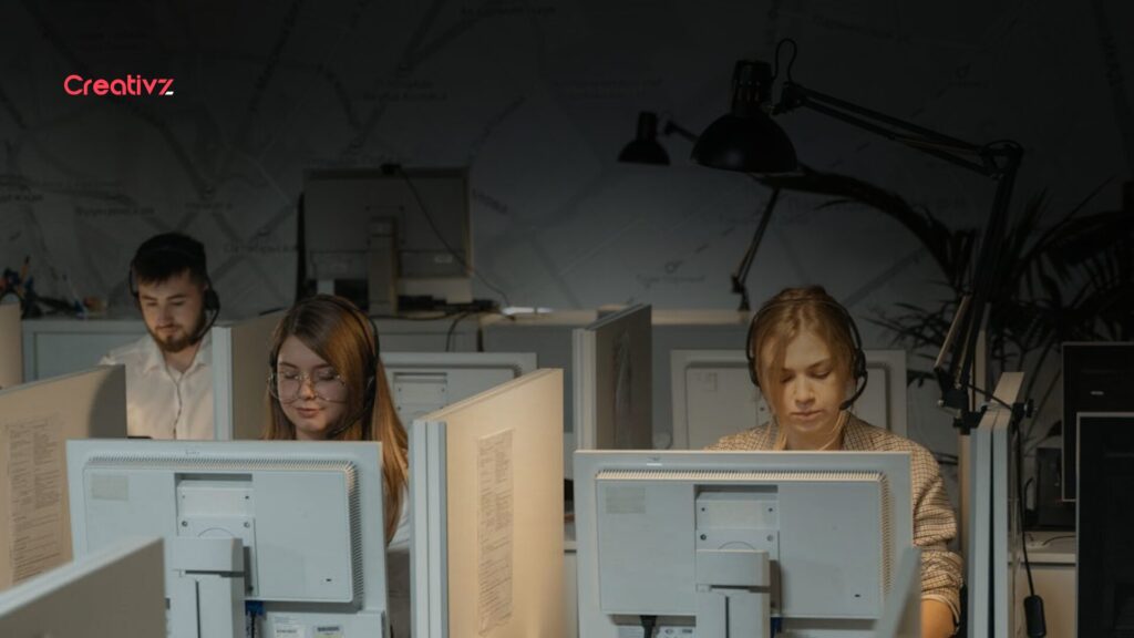 Sales operations team working at computer stations in a CRM-driven environment, representing pipeline management, lead routing, and revenue infrastructure systems.
