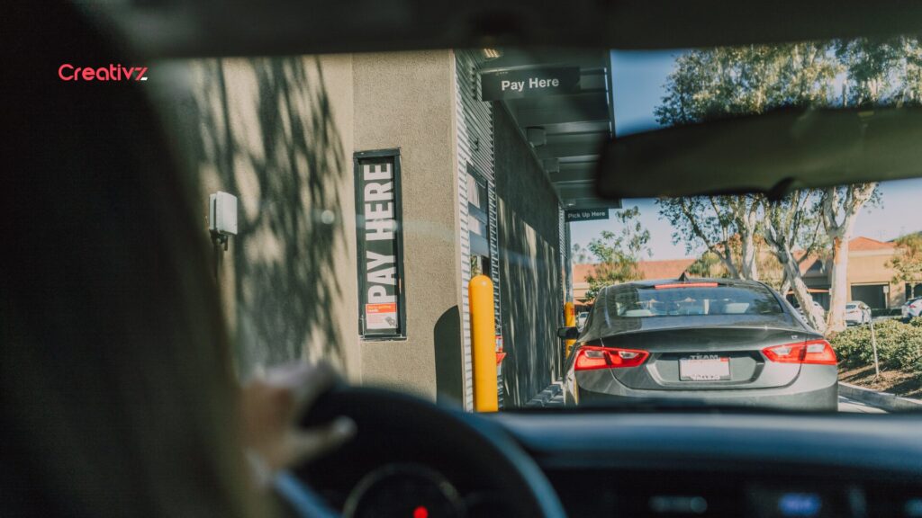 Drive-thru employee manually handling a customer order.